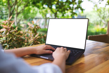 Mockup image of a woman using and typing on laptop computer with blank white desktop screen in the outdoors