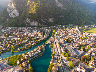 Interlaken, Switzerland: Aerial drone view of the Interlaken old town with the Aar river, the market square, the train station and cruise terminal in Canton Bern