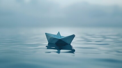 Small origami boat floating on a vast body of water with a cloudy sky above