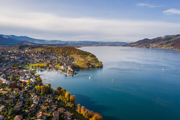 Fototapeta premium Spiez, Bern: Stunning aerial drone view of lake Thun and the Spiez village with its famous medieval castle and old town in the alps in Canton Bern in Switzerland