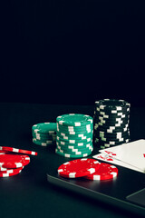 Red And Black Casino Chips On A Table With A Laptop And Playing Cards