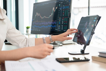 Young woman examines stock graphs at tablet