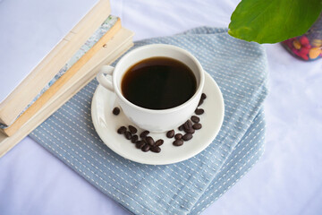 Delicious Cup of Black Coffee Americano Espresso Beans in Fancy Restaurant with Books and Plants