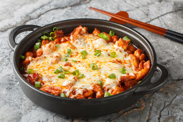 Buldak is a popular Korean spicy chicken dish served as a street food or light meal closeup on the pan on the table. Horizontal