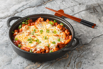 Buldak is a South Korean spicy barbecued chicken dish closeup on the pan on the table. Horizontal