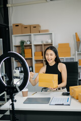 Asian lady blogger showing clothes in front of the camera to recording vlog video live streaming at...
