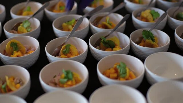 chef prepara un suculento aperitivo de pescado y mango en un banquete de bodas usando guantes azules