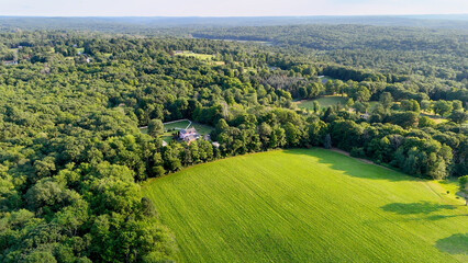 Sunset Drone photo above the green forest and farmland in rural Connecticut. Summer aerial photo of Harwinton, CT. © Michael Moloney