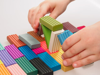 The child holds bright plastic clay in his hands, demonstrating the soft texture and rich colors