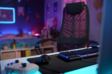Background image of gaming setup in streamers studio room with focus on LED keyboard copy space © Mediaphotos