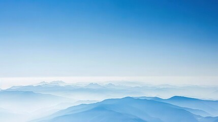   A view of a mountain range in the distance with a clear blue sky in the foreground and a hazy sky in the background