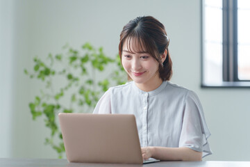 オフィスでパソコンを使って働くビジネスマン（女性・カジュアルビジネス）