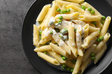 Delicious pasta with green peas and creamy sauce on grey table, top view