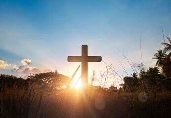 Silhouette of catholic cross at sunset background.
