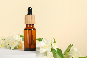 Presentation of essential oil in bottle and beautiful jasmine flowers against beige background,...
