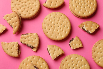 Tasty sandwich cookies on pink background, top view