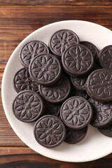 Many tasty sandwich cookies on wooden table, top view