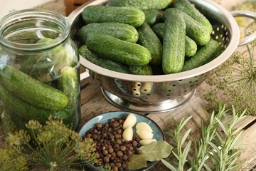 Fresh cucumbers, dill and spices on wooden table, closeup. Preparation for pickling