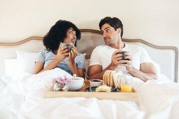 Couple, breakfast and talking in bed at house for relax, love and wellness together with support or...