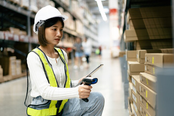 Warehouse Supervisor in safety suite use scanner to check and scan barcodes of stock inventory on...