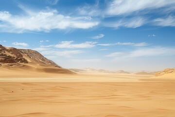 Vast desert landscape with mountains under a blue sky with clouds.