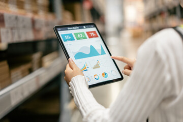 Warehouse Supervisor in safety suite using digital tablets to check the stock inventory on shelves in large warehouses, a Smart warehouse management system, logistic network technology concept.
