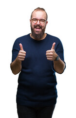 Young caucasian hipster man wearing sunglasses over isolated background approving doing positive gesture with hand, thumbs up smiling and happy for success. Looking at the camera, winner gesture.