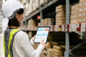 Warehouse Supervisor in safety suite using digital tablets to check the stock inventory on shelves in large warehouses, a Smart warehouse management system, logistic network technology concept.