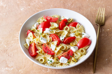 Farfalle pasta with white cheese, tomatoes and olives. Healthy eating. Vegetarian food.