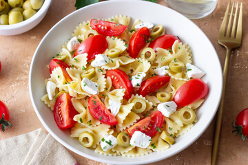 Farfalle pasta with white cheese, tomatoes and olives. Healthy eating. Vegetarian food.