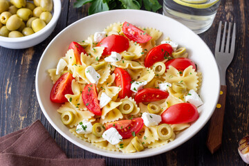 Farfalle pasta with white cheese, tomatoes and olives. Healthy eating. Vegetarian food.