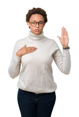 Young beautiful african american woman wearing glasses over isolated background Swearing with hand...