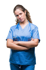 Young brunette doctor girl wearing nurse or surgeon uniform over isolated background skeptic and...