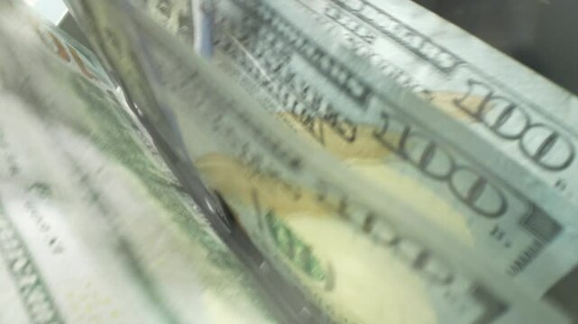 Finance and cash dollars concept. Counting dollars with electronic money counter machine. 100 dollar bills counted in money counting machine. Cash money dollars into banknote counter.