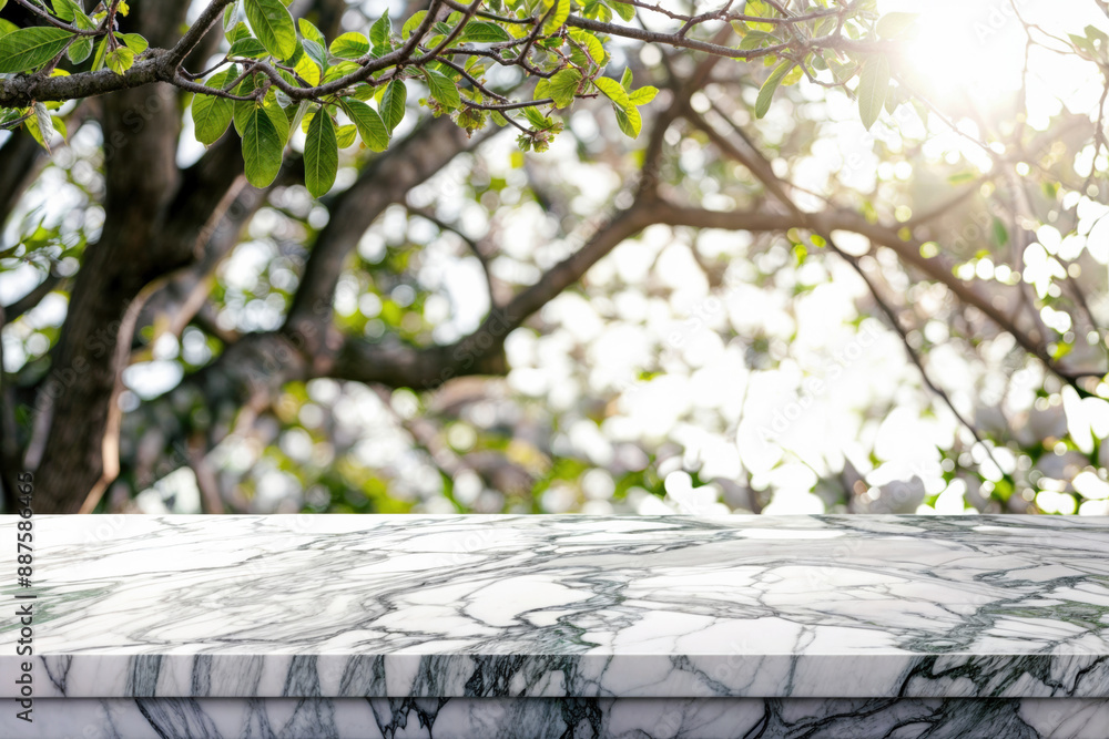 Poster empty marble table against blurred green trees, with sunlight filtering through leaves. ideal for sp