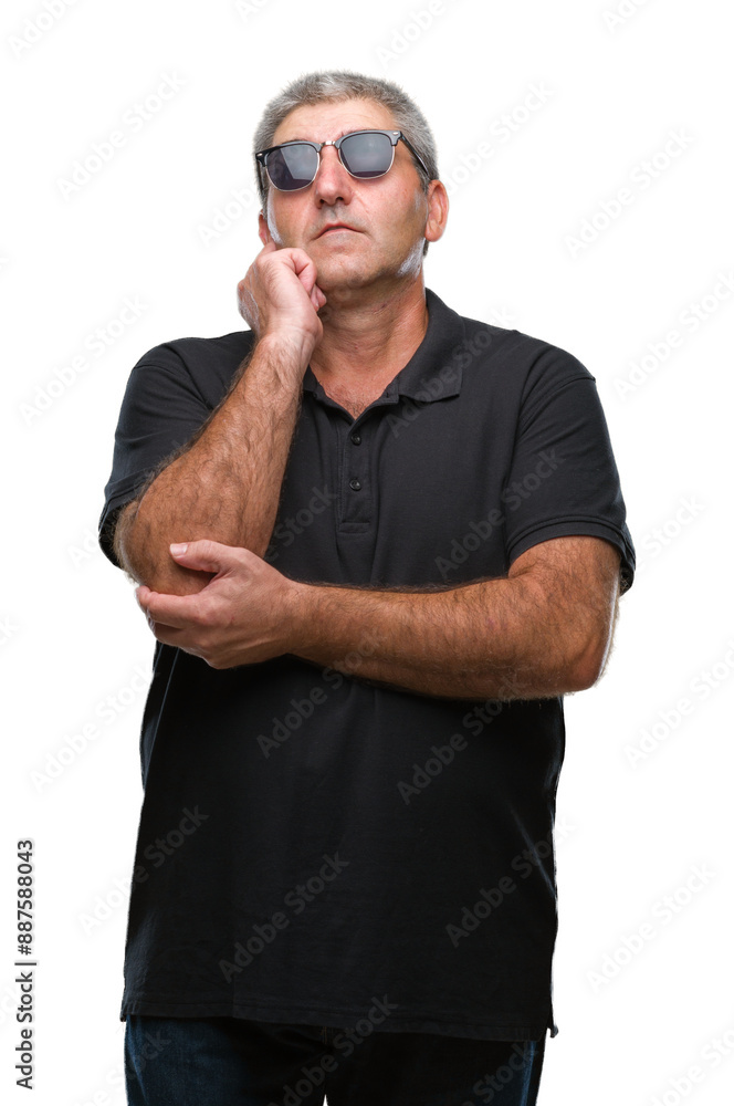 Wall mural Handsome senior man wearing sunglasses over isolated background with hand on chin thinking about question, pensive expression. Smiling with thoughtful face. Doubt concept.