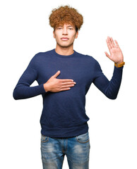Young handsome man with afro hair Swearing with hand on chest and open palm, making a loyalty...