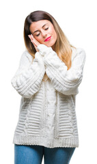 Young beautiful woman casual white sweater over isolated background sleeping tired dreaming and posing with hands together while smiling with closed eyes.