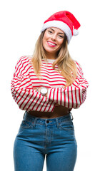 Young beautiful woman wearing christmas hat over isolated background happy face smiling with crossed arms looking at the camera. Positive person.