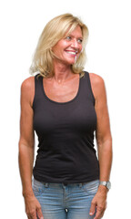 Fototapeta premium Middle age blonde woman over isolated background looking away to side with smile on face, natural expression. Laughing confident.