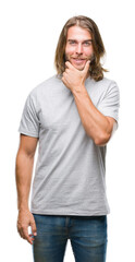 Young handsome man with long hair over isolated background looking confident at the camera with smile with crossed arms and hand raised on chin. Thinking positive.