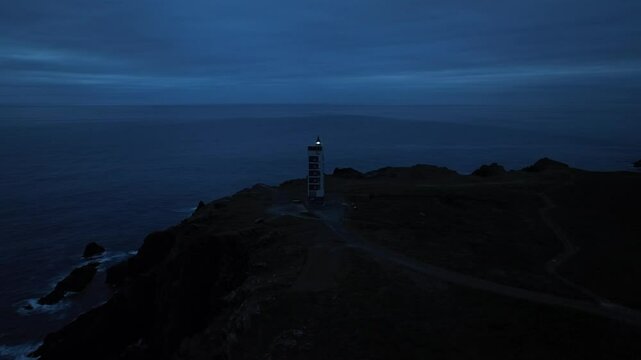 Faro de Punta Frouxeira de noche iluminando el cielo