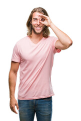 Fototapeta premium Young handsome man with long hair over isolated background doing ok gesture with hand smiling, eye looking through fingers with happy face.