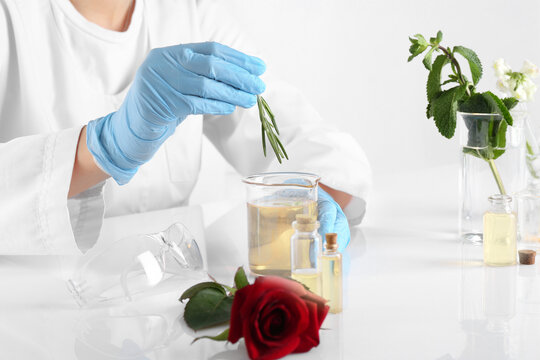 Aromatherapy product. Scientist developing essential oils at white table in laboratory, closeup