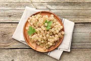 Fresh white currant berries and green leaves on wooden table, top view