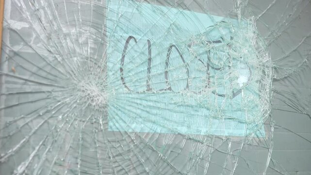 Business with shattered broken glass front door and closed sign 4k

