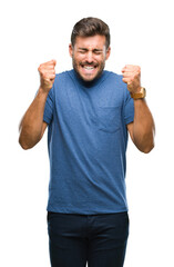 Fototapeta premium Young handsome man over isolated background excited for success with arms raised celebrating victory smiling. Winner concept.