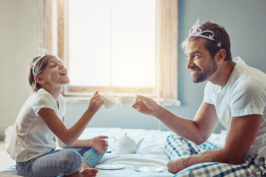 Dad, girl and fun tea party in home with smile, cheers for bonding with fantasy, tiara and support in bedroom. Growth, development and happy man with daughter on bed playing princess game in morning