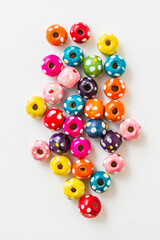 Colorful multicolored beads scattered on a white background showing vibrant colors and patterns.