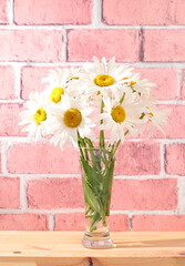 Beautiful daisy flowers in a vase on a sunny background, summer banner for product advertising, abstract floral arrangement, rustic style, holiday card, selective focus..